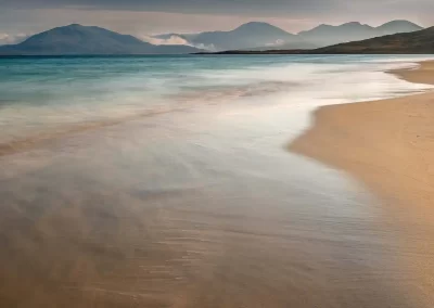 Turquoise water sweeping across the white sands of Luskentyre Beach beneath the mountains of South Harris.