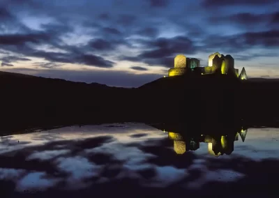 Illuminated Ruthven Barracks reflected beneath a dramatic twilight sky near Kingussie in the Cairngorms National Park.