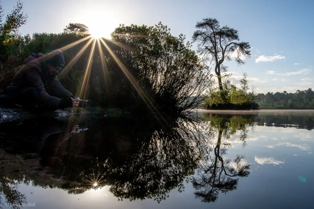 A guest captures the soft morning light and reflections of trees in the still waters of a lake at sunrise, during a landscape photography tour with Nature Talks UK. Photo taken by Louis Guillot.